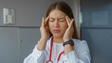 Hastanenin dışında steteskop ve saat takan kadın doktor, kentin tıbbi ortamında stresi temsil ediyor..