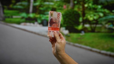 Şehir parkındaki açık alanlarda Norveçli kronlar el ele tutuşarak, açık bir günde şehir ortamında yatırım ya da iş anlamına gelir..