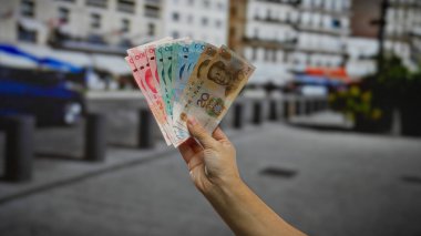 Bir şehir merkezindeki iş ve para birimi üzerinde Çin Yuan banknotları el ele tutuştu.