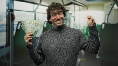 Hispanik bir adam otobüsün içinde neşeli bir şekilde Rus rublesi tutuyor. Geçmişi bulanık, beklenmedik bir şekilde mali başarı gösteriyor..