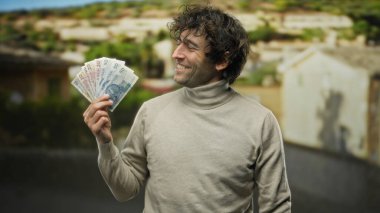 Bir şehir caddesinde gülümseyen, Polonya 'da canlı bir para ve kültürel çeşitlilik manzarası yakalayan İspanyol bir adam..