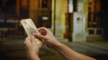 Bir kapalı müze ortamında Norveç banknotları tutan adam, finans ve yatırım temaları vurgulanıyor.