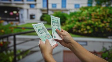 Bir şehir merkezinde Çin yuanı banknotlarını tutan eller ticari finans ve para değişimi kavramlarını yansıtıyor..