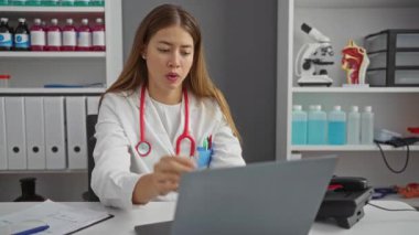 Üniformalı genç bir kadın klinikteki mahcup ifadesini gizlemek için parmaklarının arasından gizlice bakıyor.