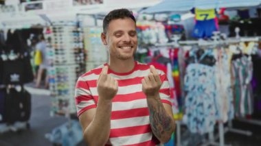 Şehir dışında bir markette el kol gezen genç adam, hayat dolu bir şehir ortamında mutluluk ve güveni ifade ediyor..