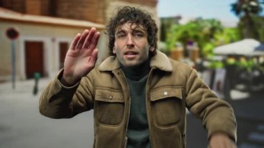 Kahverengi ceketli genç adam bir şehir caddesinde hareketli bir şekilde, şehir içinde heyecan ve çatışma taşıyor..