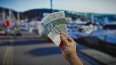 Deniz kenarı şehir ortamında el ele tutuşan Hong Kong doları, para birimi ve açık hava koşullarına odaklanarak, iş ve yatırım fırsatları öneriyor..