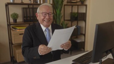 Ofis ortamında belgeyi okurken gülümseyen kıdemli bir adam başarı ve mutluluk öneriyor..
