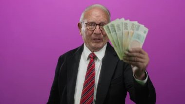 İş ve finans konularında tecrit edilmiş pembe bir geçmişe karşı elinde Czech Koruna banknotları tutan kıdemli bir adam.