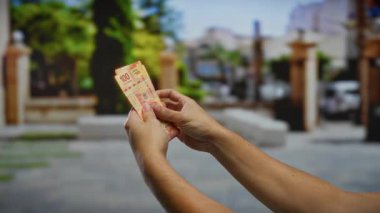 Meksika pesolarını şehir sokaklarında tutan adam şehir merkezinde mali yatırım ve iş işlemlerini vurguluyor..