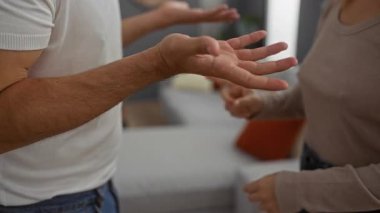 Kadın ve erkek sıcak bir oturma odasında tartışıyor, ev ortamında bir ilişki dinamiğini öneriyorlar..