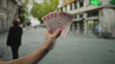 Açık şehir caddesinde el ele tutuşan Türk lirası banknotları. Bulanık bir geçmişi var..