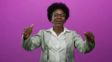 Kendine güvenen bir kadın, pembe bir arka plana, gözlüklü, gri ceketli, kendine güvenen ve profesyonelce davranan bir kadına dikkat çekiyor..