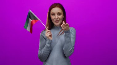 Elinde kuveyt bayrağı olan bir kadın beni pembe duvara karşı çağırır neşeli dostluk gösterir..