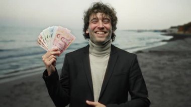 Tayland 'da sahilde gülümseyen ve neşe ve başarıyı resmeden bir adam..