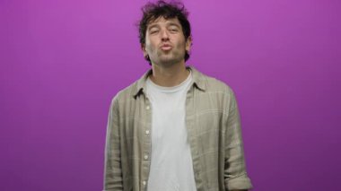 İspanyol adam canlı pembe arka planda gülümsüyor, günlük ekose gömlek ve beyaz tişört giyiyor, büyüleyici ve kendine güvenen..