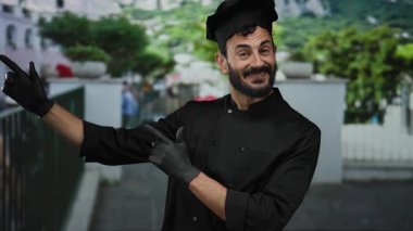 Siyah şef üniformalı İspanyol adam ve sakallı şapkalı mutlu bir şekilde açık hava arka planında, çekici ve davetkar..