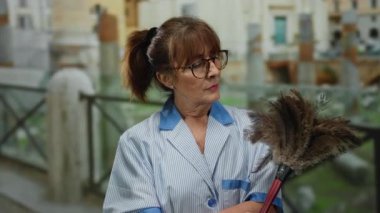 Üst düzey İspanyol kadın üniforma ve gözlük takarak Roma harabelerinin yakınında tozunu alıyor..