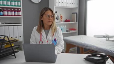 Hasta kayıtları ve sağlık ekipmanlarıyla tıbbi klinikte işbirliği yapan doktorlar ve hemşireler arka planda görünür..