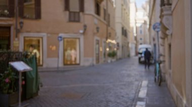 Roma 'da bulanık insanların olduğu bulanık bir sokak sahnesi, gösterişli eski kasaba cazibesi, kaldırım taşı yolu, Avrupa mimarisi, ve rüya gibi bir ortam yaratan bir bokeh etkisi..