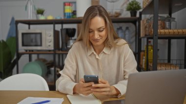 Ofis ortamında akıllı telefon kullanan bir kadın modern iş ortamını teknoloji kullanan genç ve çekici bir yetişkinle kapalı alanda gösteriyor..