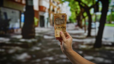 Kentsel sokak geçmişine karşı Güney Afrika Rand banknotları, hareketli bir şehir ortamında mali işlemleri veya döviz alışverişini sembolize ediyor.