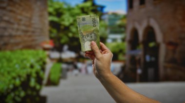 Şili pezo banknotunun el ele tutuşması kentsel sokak ayarı güneş ışığı altında açık havada canlı şehir atmosferinde finansal yatırım kavramı sergileniyor..