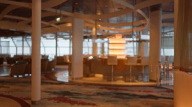 Lüks bir restoranın içi bulanık. Bokeh ışıklandırması, zarif bir dekor ve sessiz renkler sergiliyor. Sofistike bir ortam yaratıyor..