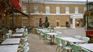 Londra 'daki bulanık sokak kafe sahnesi, bir kış ya da sonbahar aylarında açık masa ve sandalyelerin sergilenmesi, Birleşik Krallık' taki kentsel yaşamın özünü yakalamak..