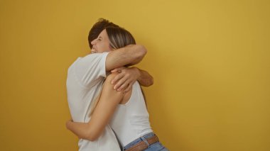 Parlak sarı bir arka plana sevinçle sarılan çift, güçlü bir bağ ve mutluluk sergiliyor..