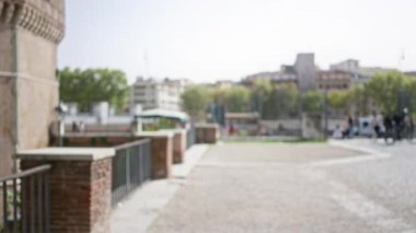 Roma 'nın pitoresk eski kasabasında parlayan güneş ışığı altında odakları kesilmiş insanların ve tarihi mimarinin olduğu bir İtalyan caddesinin bulanık görüntüsü..