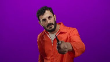 Portakal rengi hapishane tulumlu İspanyol bir adam elinde mor arka planda bıçak tutuyor. Sinema ortamında gerginlik ve tehlike olduğunu gösteriyor..