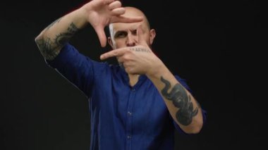 Dövmeli bir adamın elleri önünde siyah arka plana karşı hareket etmesi yaratıcılığı ve odaklanmayı akla getiriyor.