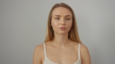 Beyaz arka planda uzun sarı saçlı, gülümseyen bir kadın doğal güzellik ve kendine güvenini sergiliyor..