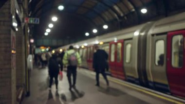 Londra yeraltı platformunun bulanık görüntüsü. Odaklanamayan insanlar ve trenlerin kentsel ulaşım ortamında bokeh etkisi yaratması..