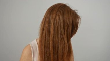 Beyaz arka planda kolsuz bluzlu, kızıl saçlı bir kadın, güzel ve pozitiflik tasvir ediyor, rahat tavırlı, çekici, beyaz bir kadın sunuyor..