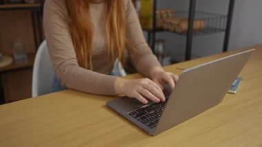 Ofis ortamında dizüstü bilgisayar kullanırken sırt ağrısı çeken bir kadın, kızıl saçlı yetişkin bir kadın, modern bir dekor ile işyeri ortamında rahatsızlık gösteriyor..