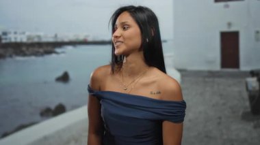 Deniz kenarındaki gezinti güvertesinde dürbünlü jest yapan, arka planda denizle Latin ve İspanyol yeteneklerini sergileyen, açık hava eğlencesi ve eğlenceyi harmanlayan bir kadın..