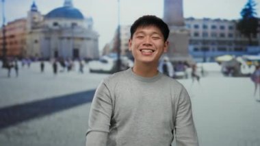 Vatikan 'da gülümseyen genç bir adam arka planı olarak güzel bir tarihi kare ile, canlı bir şehir atmosferini yakalıyor..