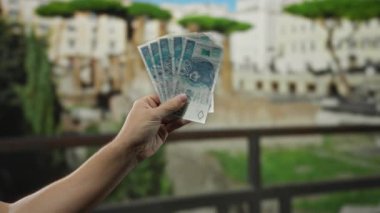 Polonya 'da bir şehir caddesinde temiz bir gökyüzünün altında, paralar tutan bir adamın eli..