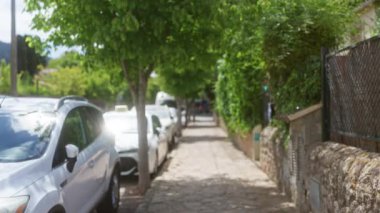 Bulanık cadde manzarası, park halindeki arabalar ve ağaçlar Mallorca 'da güneşli bir kaldırım.