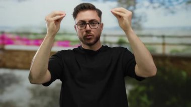 Sakallı genç, beyaz bir adam, şehir dışındaki bir sokak ortamında, şehir duygularını ve ifadesini aktararak stres yapıyor..