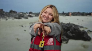 Gülümseyen sarışın gönüllü kumsal açık deniz genç beyaz kayalar arka planda neşeli dost kazak