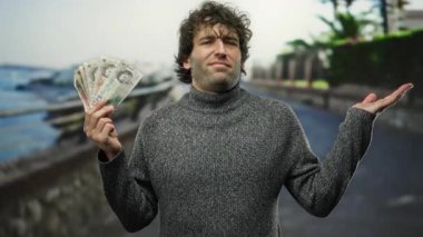 İspanyol asıllı bir adam sahilde, elinde şaşkın bir ifadeyle İngiliz paundu tutuyordu. Sahilde bir arka plana kurulmuş, finans ve boş zamanların yan yana gelişini vurguluyordu..