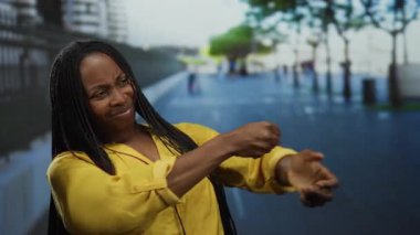 Sarı elbiseli kadın, şehir caddesinde hayali bir ipe asılıyormuş gibi yapıyor duygularını dışa vuruyor yaratıcı, dengeli sahne arkası güzel yetişkin sahne şehri.