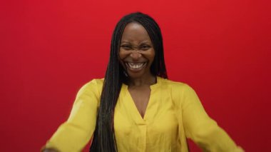 Mutluluktan gülümseyen bir kadın parlak kırmızı duvarlara sarılar takıyor. Mutluluk ve pozitifliği anımsatıyor. Canlı bir ortamda izole edilmiş.