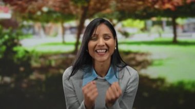 Neşeli bir parkta, sonbahar renkleriyle ve sıcak, güneşli bir atmosferle neşeli bir kutlama yapan kadın heyecan ve mutluluğu ifade ediyor..