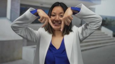 Şehir sokaklarında gün ışığında beyaz ceket ve mavi bluz giymekten hoşlanmadığını belirten genç bir kadın.