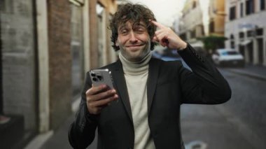 Genç adam kafasına düşünceli bir ifadeyle dokunuyor, akıllı telefonu şehir sokaklarında tutuyor, teknolojiyle harmanlıyor..