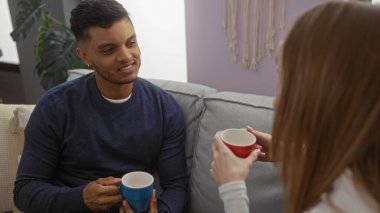 Kadın ve erkek oturma odasında oturup kahvenin tadını çıkarıyorlar. Sıcak, samimi bir ortam sergiliyorlar. İlişkinin önemini vurguluyorlar..